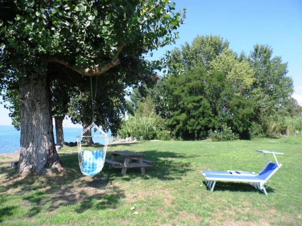 Lettini e alberi sulla spiaggia privata del Lago di Bolsena
